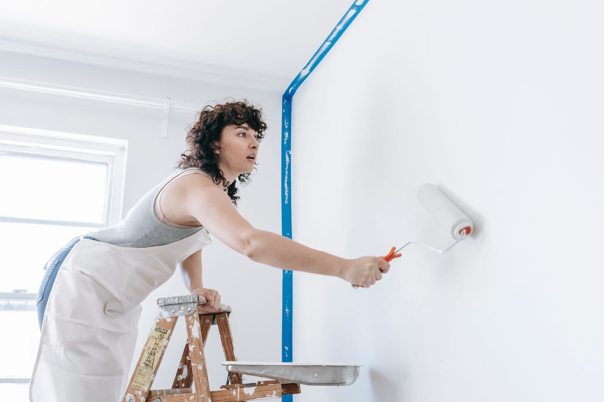 A painter rolling a smooth, even coat onto an interior wall